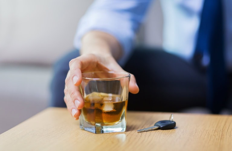Can a DUI Be Expunged in Indiana? - Kaushal Law LLC male driver hand with whiskey glass and car key on table