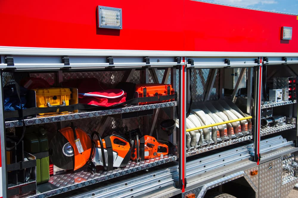 Compartment of rolled up fire hoses on a fire engine. Rescue fire truck equipment